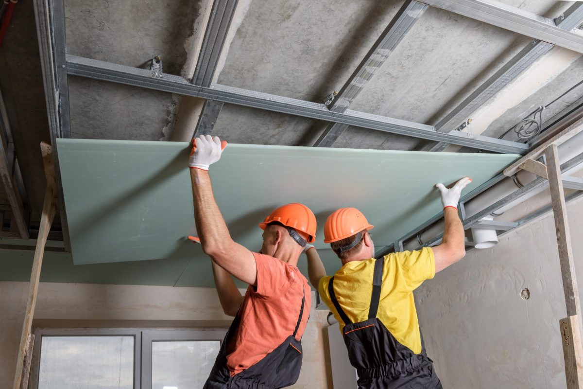workers-are-lifting-plasterboard-further-attaching-ceiling-min